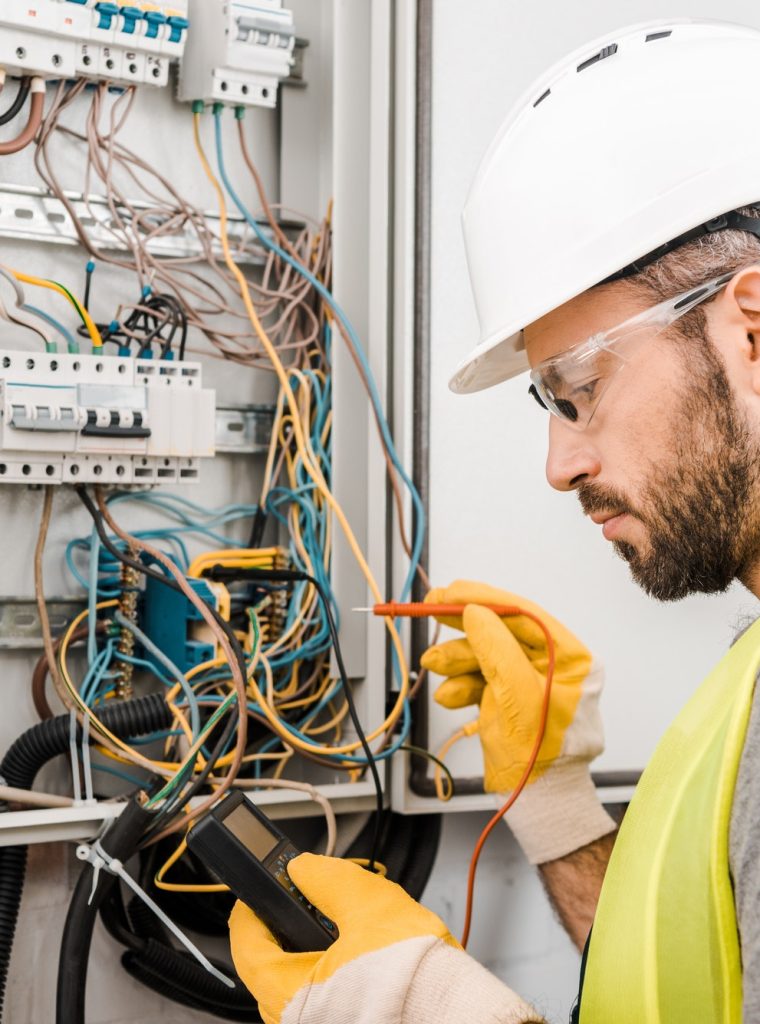 handsome-electrician-checking-electrical-box-with-multimetr-in-corridor.jpg